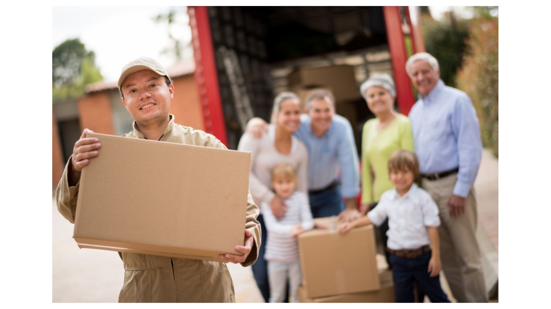 Half Price Movers crew member carrying a box from a moving truck for a happy multigenerational family